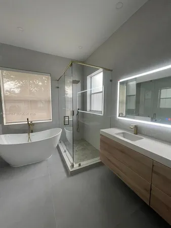 a spacious bathroom with a tub sink and mirror