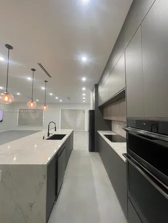 a kitchen with kitchen island a sink stainless steel appliances and cabinets