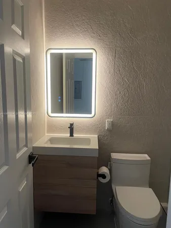 a bathroom with a toilet sink and mirror