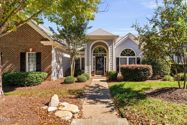 a front view of a house with a yard and outdoor seating
