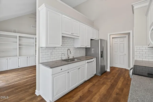 a kitchen with stainless steel appliances a sink a stove cabinets and a kitchen island