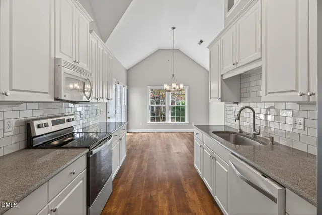 a kitchen with stainless steel appliances granite countertop a sink a stove and cabinets