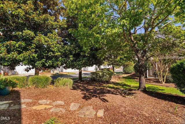 a view of a house with a yard and large tree