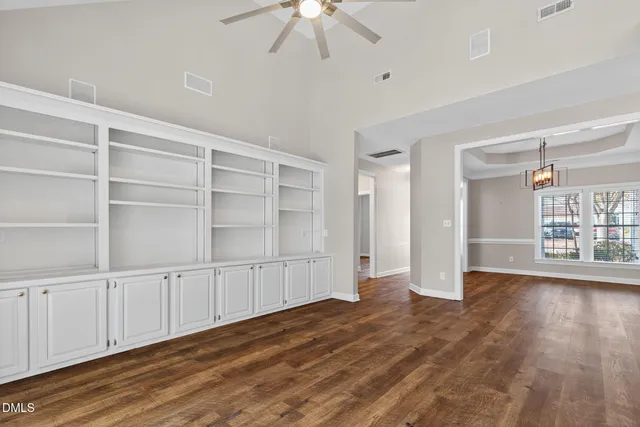a view of an empty room with wooden floor and closet