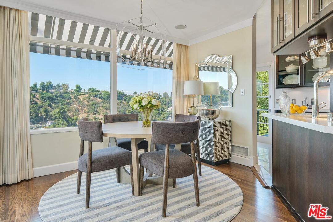 2019 Stradella Road Los Angeles, CA 90077 - Photo 13 of 45 a dining room with furniture a rug a potted plant and wooden floor