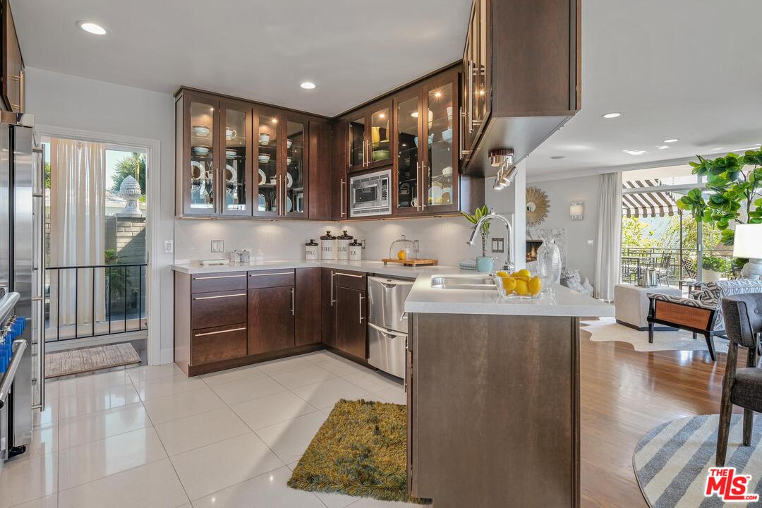 2019 Stradella Road Los Angeles, CA 90077 - Photo 14 of 45 a kitchen with stainless steel appliances kitchen island granite countertop a refrigerator a stove top oven a sink with dining table and chairs