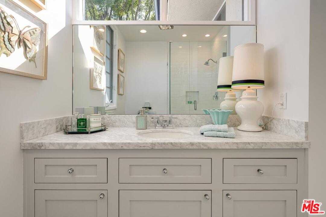 2019 Stradella Road Los Angeles, CA 90077 - Photo 25 of 45 a bathroom with a granite countertop white vanity white cabinets and two mirrors