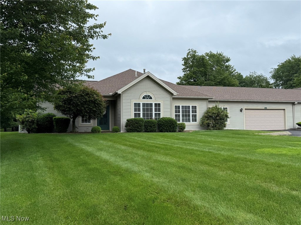 5645 Clingan Road, Unit 2D Struthers, OH 44471 - Photo 4 of 50 Single story home featuring an attached garage, a front yard, driveway, and a shingled roof