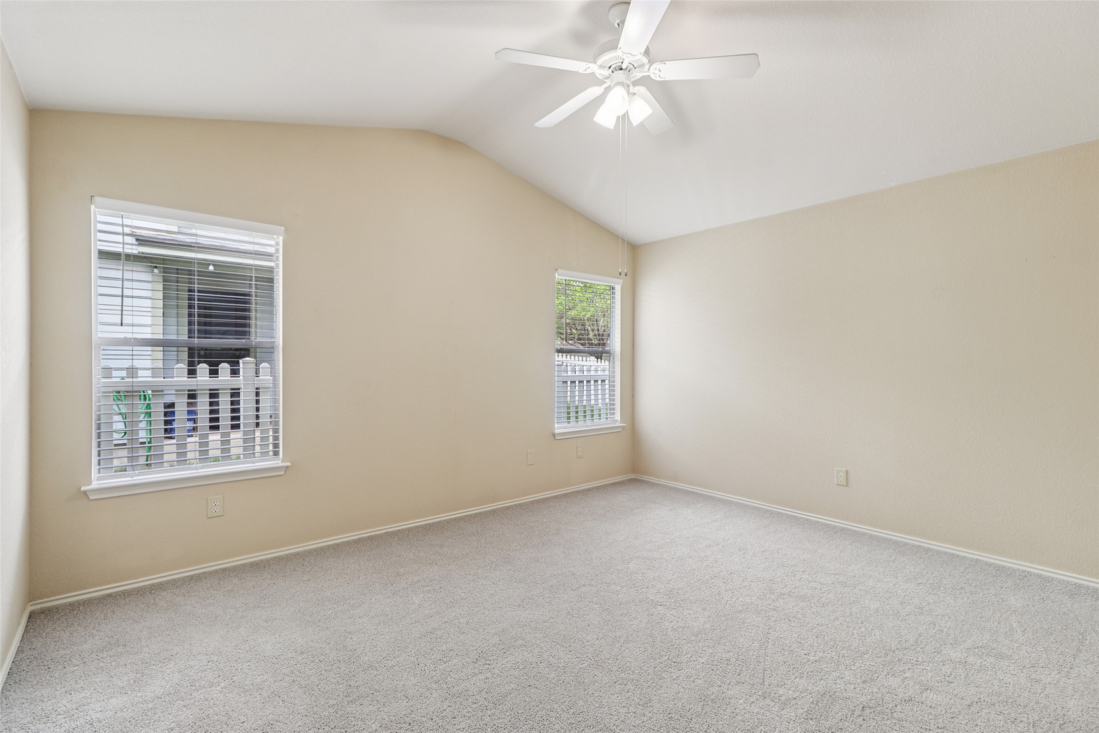 700 Scheel Road Kyle, TX 78640 - Photo 22 of 39 Spacious room featuring vaulted ceilings, light-colored walls, and two windows providing natural light