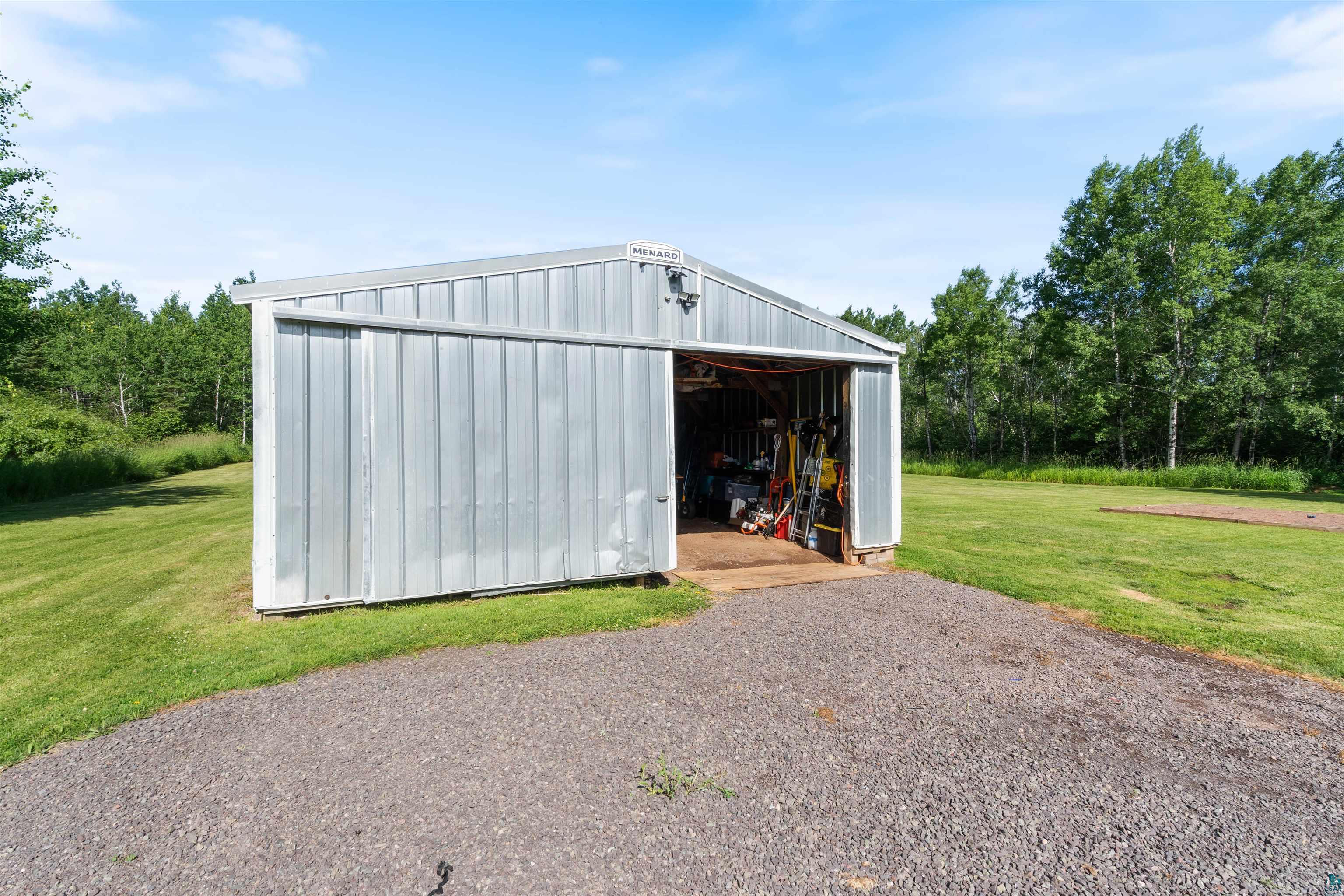 3835 South County Rd K South Range, WI 54874 - Photo 3 of 29 Metal utility shed with sliding entry door, set on a gravel pad