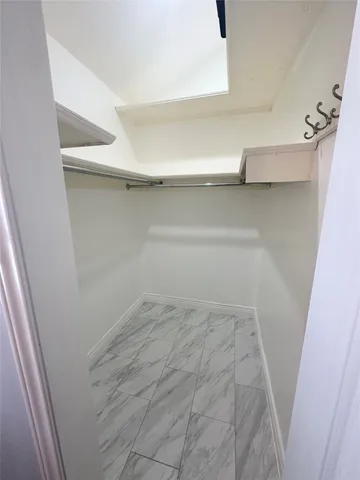 a view of walk in closet with empty racks