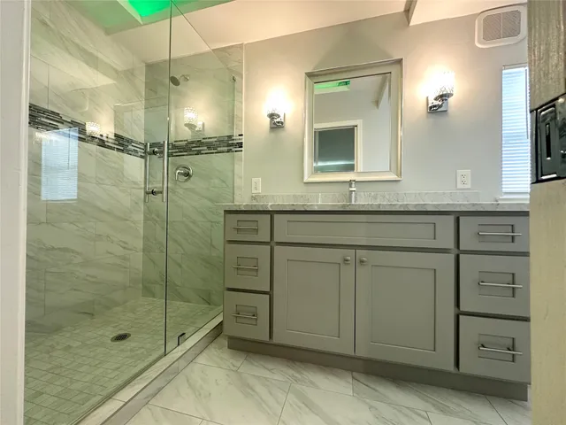 a bathroom with a shower sink and mirror