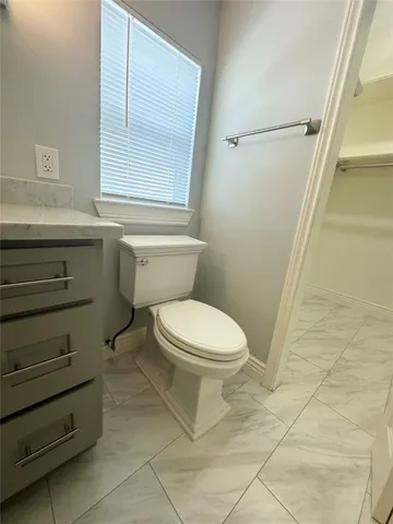 a bathroom with a toilet a sink and a window