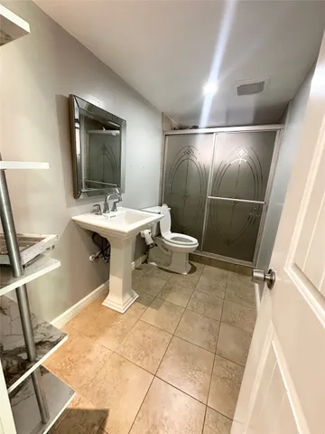 a bathroom with a sink toilet and shower