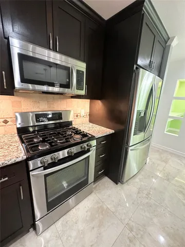 a kitchen with stainless steel appliances granite countertop a stove microwave and sink