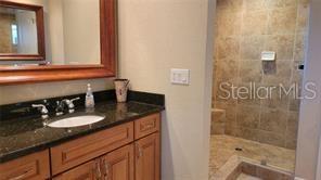 650 Golden Gate Point, Unit 301 Sarasota, FL 34236 - Photo 21 of 31 a bathroom with a granite countertop sink a mirror and shower