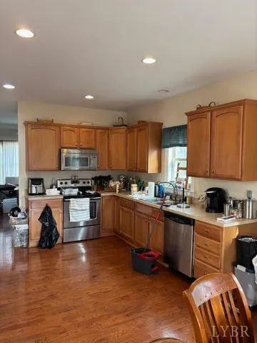 a kitchen with stainless steel appliances a sink a stove a refrigerator cabinets and a center island