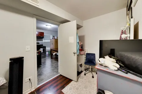 a hallway with a couch and a dining table with wooden floor