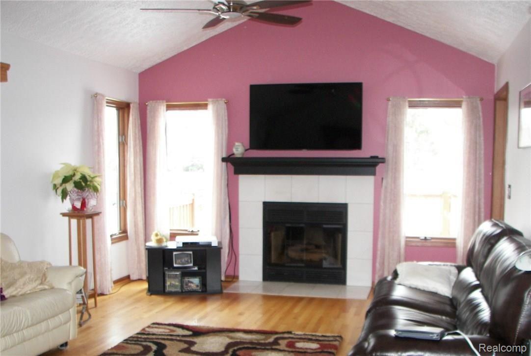 6788 Kestrel Ridge Road Brighton, MI 48116 - Photo 6 of 18 Family room with gas fireplace, wood floors and ceiling fan. Lots of natural light.