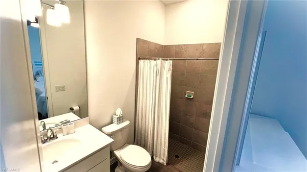 a bathroom with a granite countertop sink toilet and shower