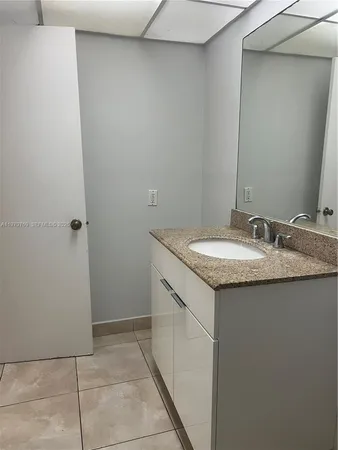 a bathroom with a granite countertop sink and a mirror