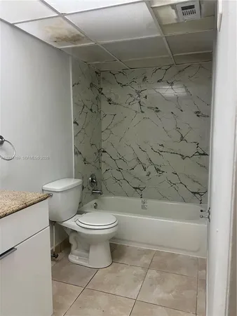 a bathroom with a granite countertop toilet a sink and a shower