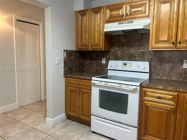 a kitchen with granite countertop white cabinets stainless steel appliances and sink