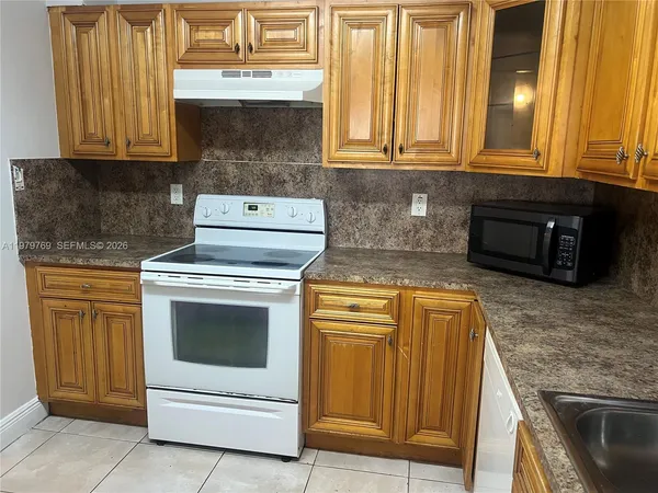 a kitchen with granite countertop cabinets stainless steel appliances and a counter space