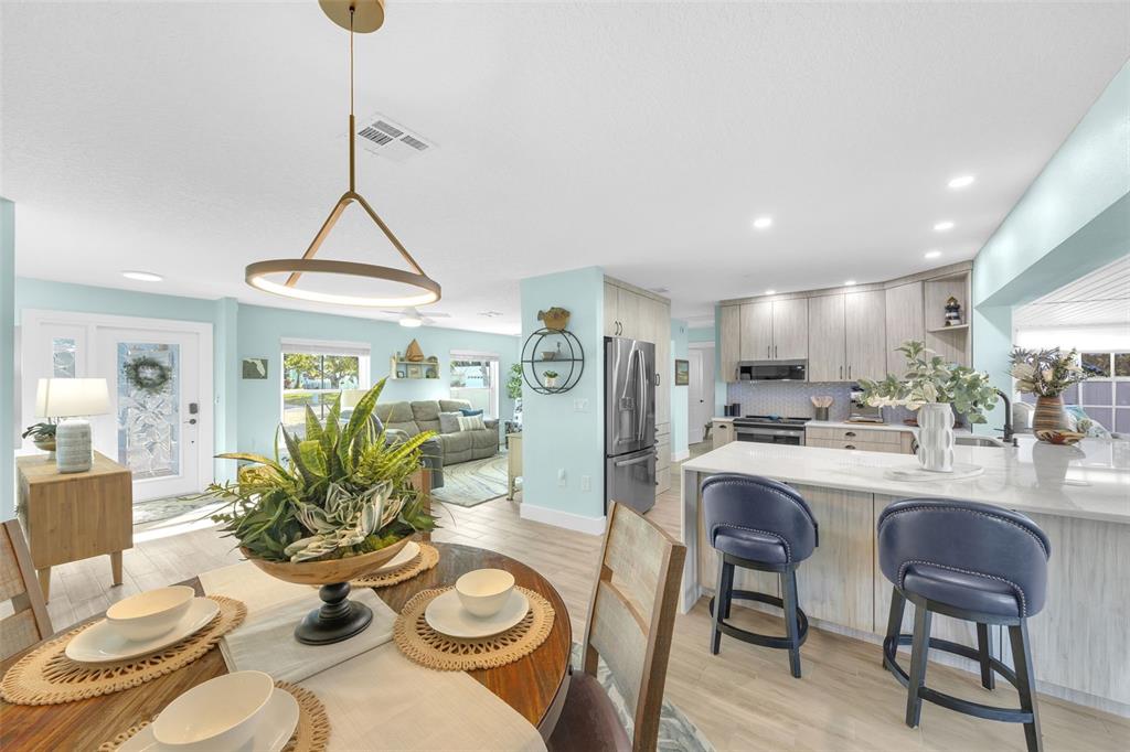 1015 Spindle Palm Way Apollo Beach, FL 33572 - Photo 21 of 78 a kitchen with stainless steel appliances kitchen island granite countertop a dining table chairs and white cabinets