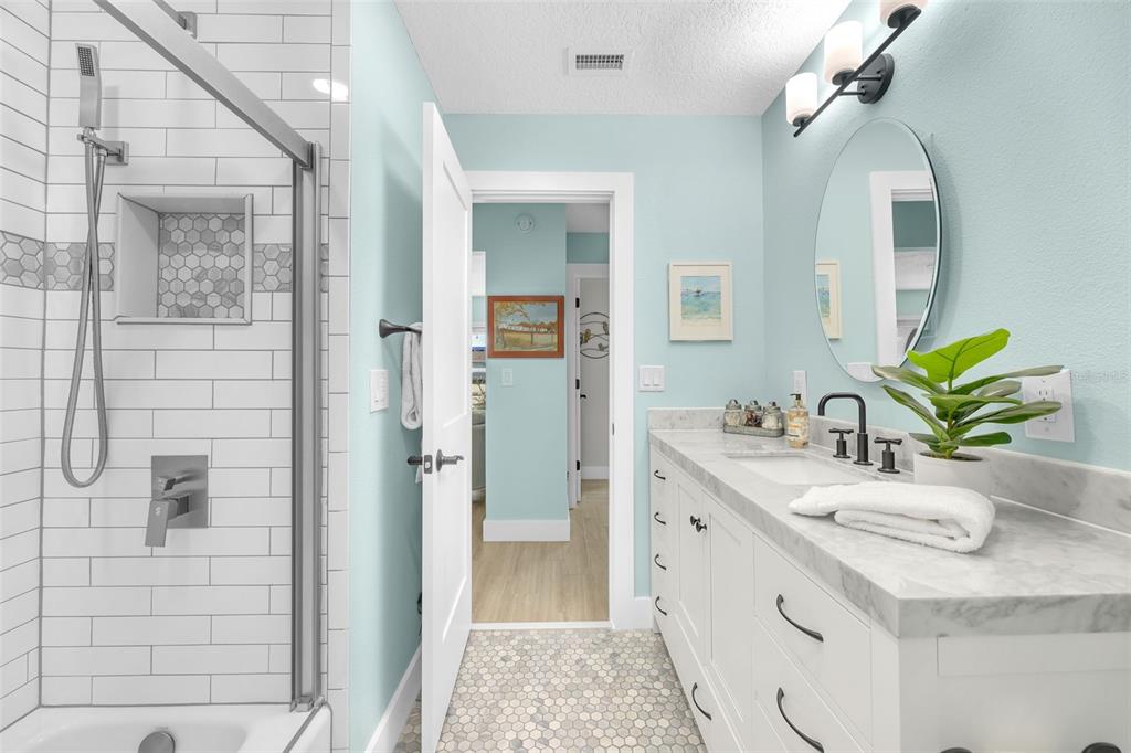 1015 Spindle Palm Way Apollo Beach, FL 33572 - Photo 52 of 78 a bathroom with a granite countertop sink a mirror and shower