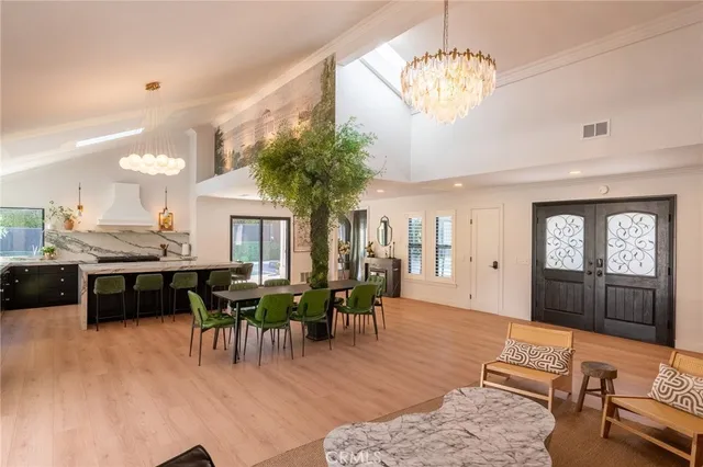 a living room with furniture a chandelier a dining table and kitchen view