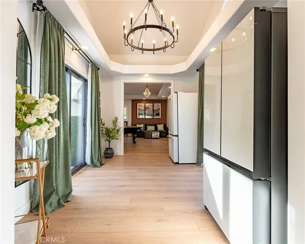 a view of a hallway with furniture and a chandelier