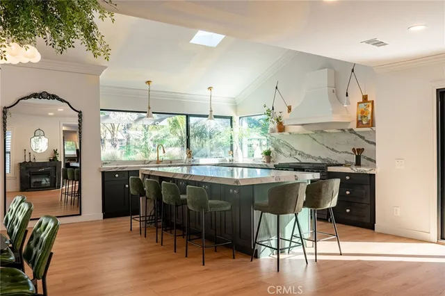a kitchen with a table chairs sink and wooden floor