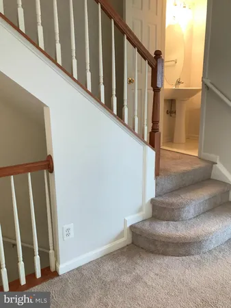 a view of staircase with lots of frames on wall and a window