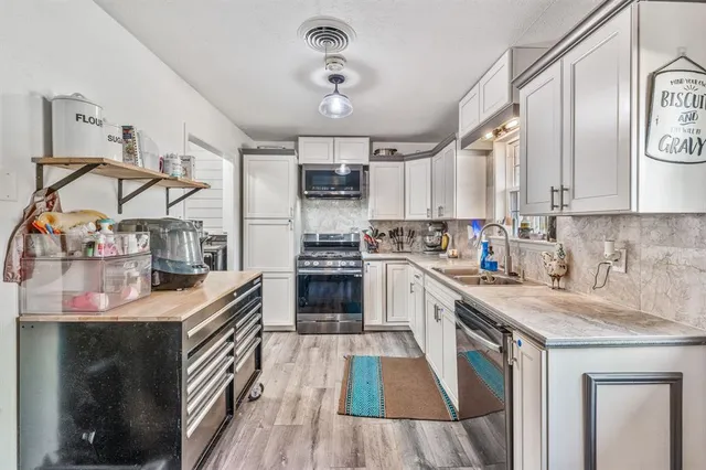 a kitchen with stainless steel appliances granite countertop a sink stove and refrigerator