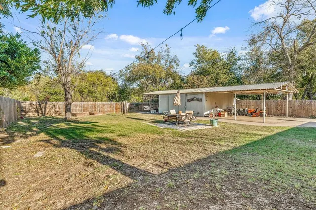 a view of a patio with table and chairs under an umbrella