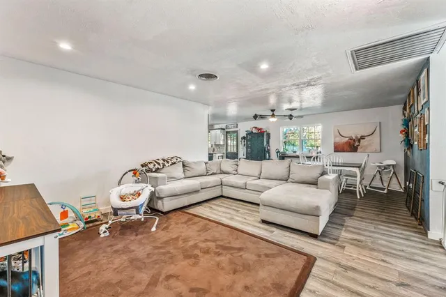 a living room with furniture and a wooden floor