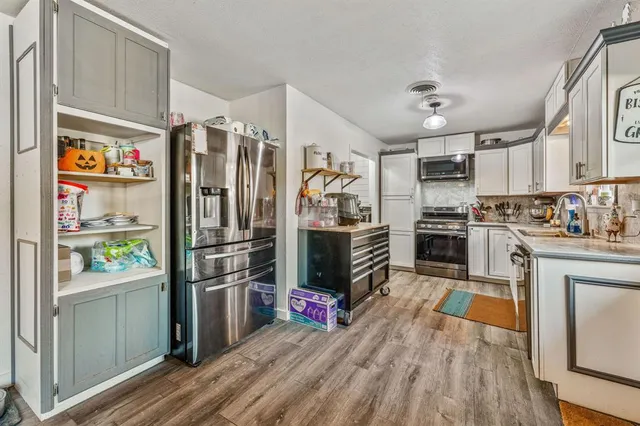 a kitchen with stainless steel appliances a refrigerator sink and microwave