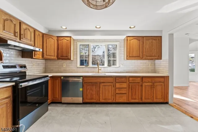 a large kitchen with granite countertop a stove and a sink