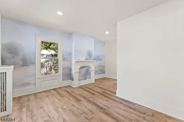 a view of empty room with window and wooden floor