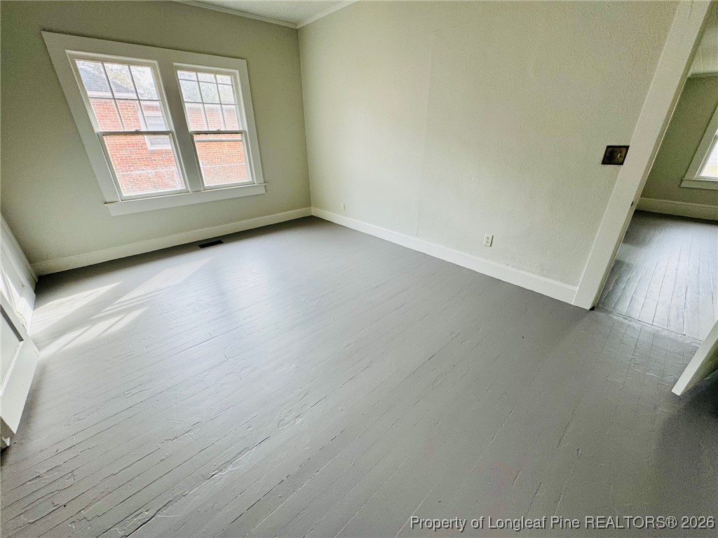 411 Carthage Road Lumberton, NC 28358 - Photo 11 of 25 an empty room with wooden floor and windows