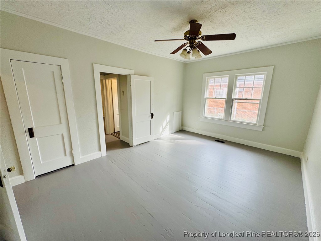 411 Carthage Road Lumberton, NC 28358 - Photo 21 of 25 an empty room with wooden floor fan and windows