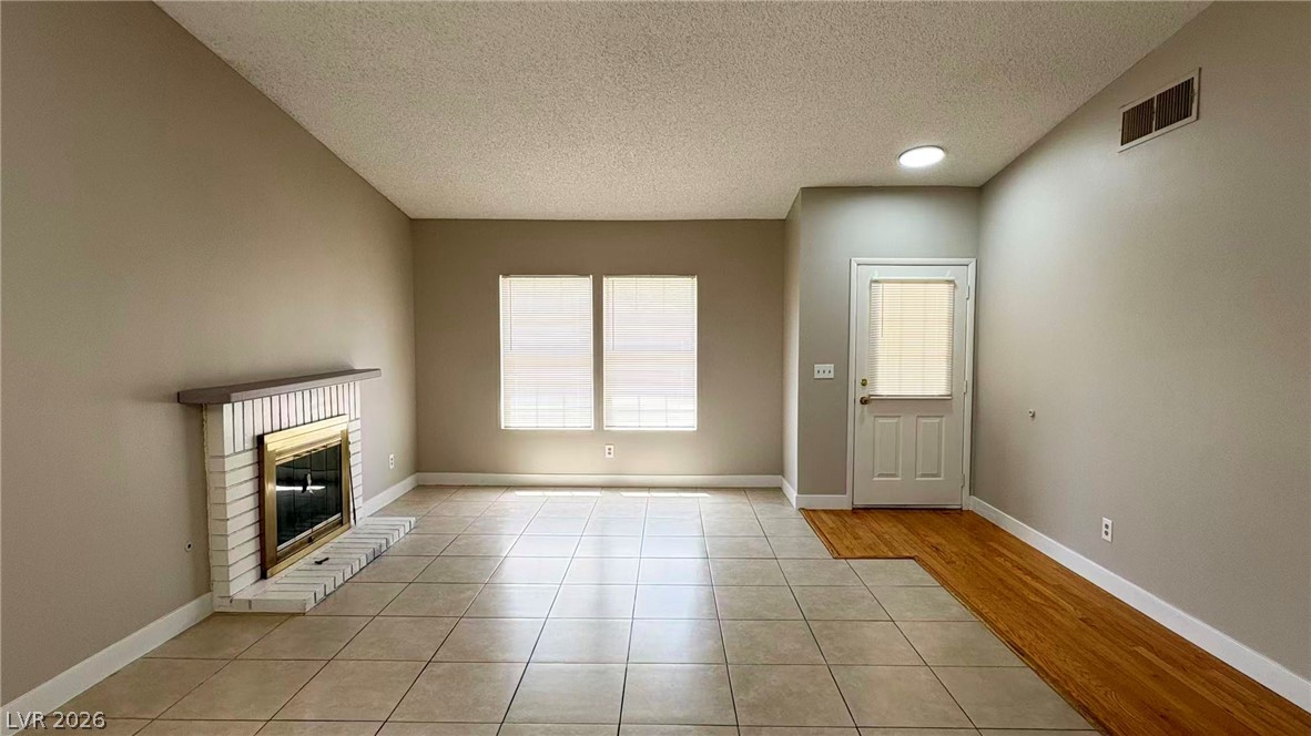 4325 Newcastle Road Las Vegas, NV 89103 - Photo 5 of 18 A classic fireplace with a white brick surround anchors this inviting, naturally illuminated living space.