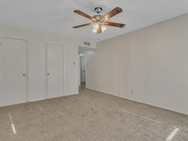 an empty room with a chandelier fan