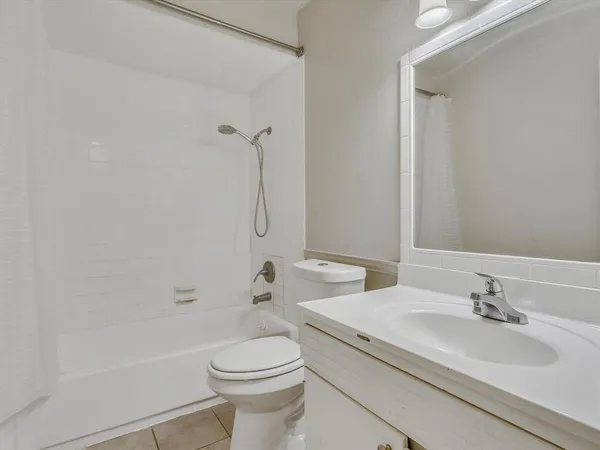 a bathroom with a granite countertop sink a toilet and a bathtub