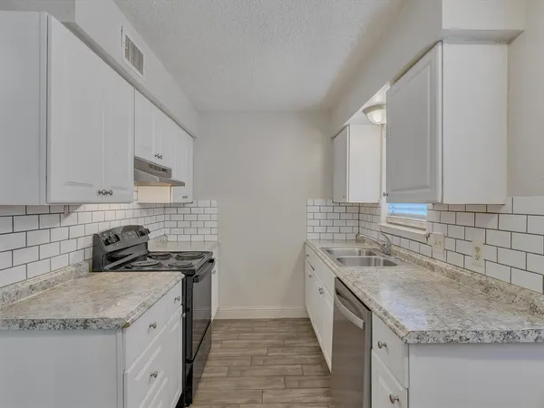 a kitchen with stainless steel appliances granite countertop a sink stove and cabinets
