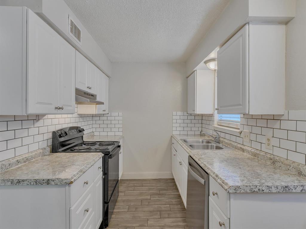 5053 Ridglea Lane, Unit 911 Fort Worth, TX 76116 - Photo 5 of 16 a kitchen with stainless steel appliances granite countertop a sink stove and cabinets