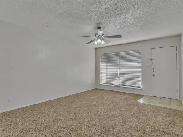 an empty room with chandelier fan