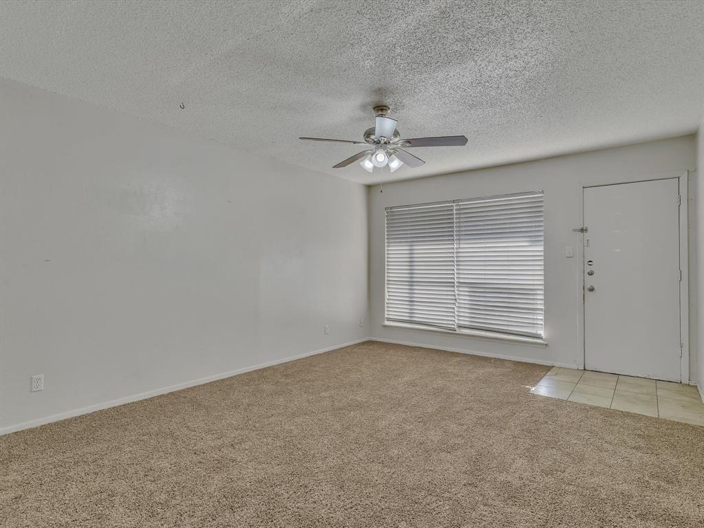 5053 Ridglea Lane, Unit 911 Fort Worth, TX 76116 - Photo 9 of 16 an empty room with chandelier fan