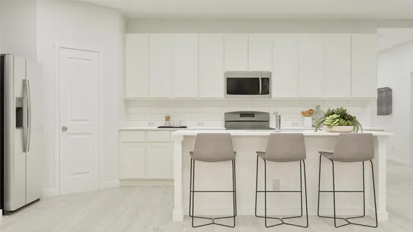 a kitchen with stainless steel appliances a stove a sink and a refrigerator